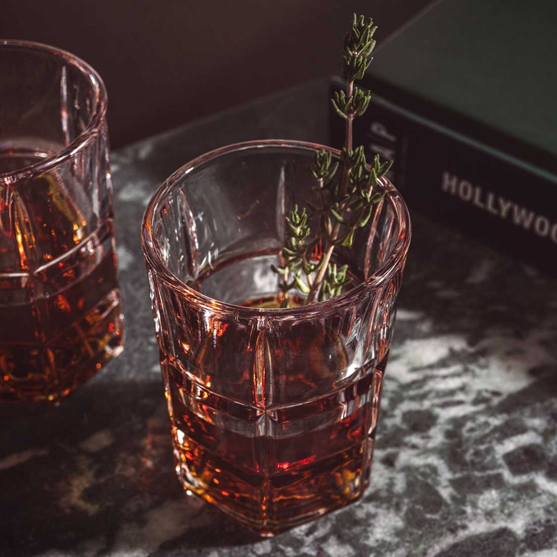 Stamper SPIRITII NOVA mit Whiskey gefuellt, Kraeuter-Garnish, auf dunklem Marmor-Untergrund