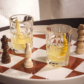 Zwei Stamper SPIRITII NOVA mit Whiskey auf Schachbrett neben Schachfiguren