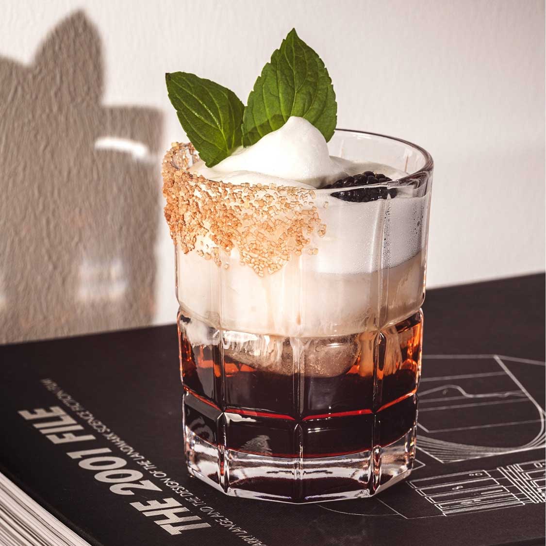 Trinkglas SPIRITII NOVA mit Cocktail, Minze und Zuckerrand auf schwarzer Oberfläche