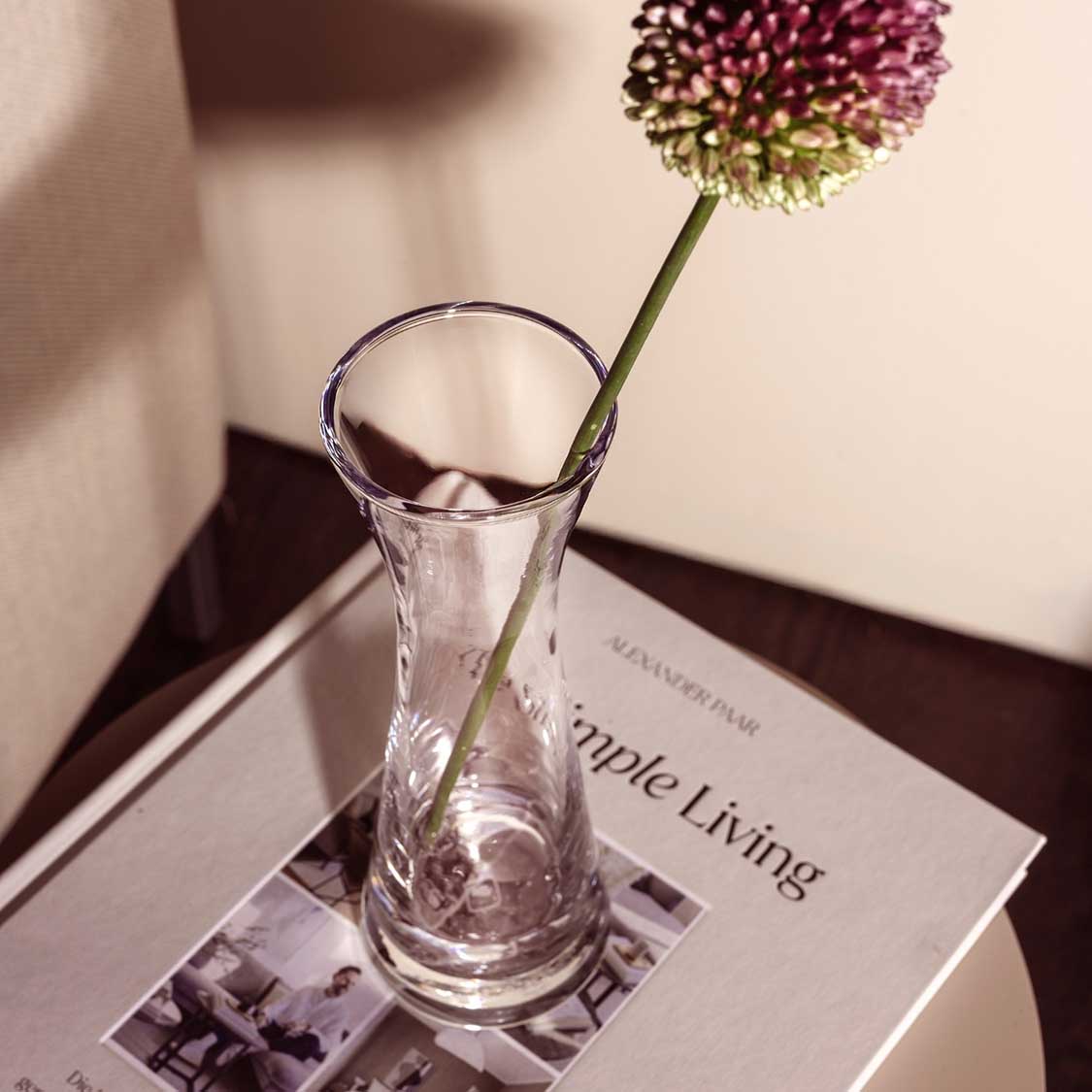 Solifleurvase GIA mit pinker Blüte auf Zeitschrift, Schreibtisch-Szenerie