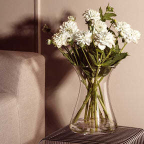 Vase GIA mit weissen Blüten in Wohnraum neben Sessel