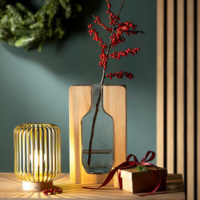 Holzvase AUTENTICO mit roten Beeren, goldene Lampe und Geschenkbox auf Tisch