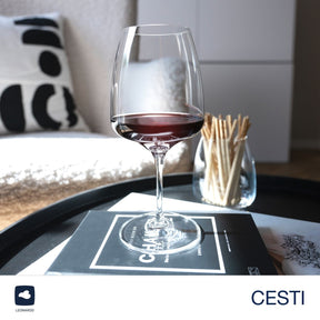 Weinset CESTI mit gefülltem Kelchglas auf schwarzem Tablett, Streichhölzer und Kissen im Hintergrund