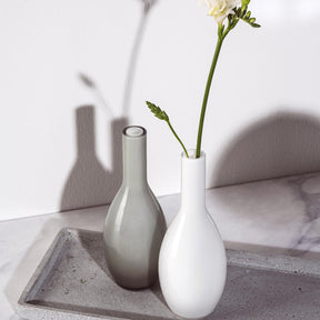 Vase BEAUTY 18 cm grau neben weißer Vase mit Blumen auf Betonablage