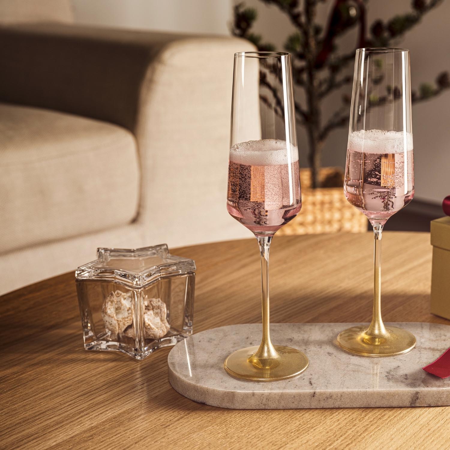 Sterndose RIPOSO auf Marmortablett neben Sektgläsern im Wohnzimmer