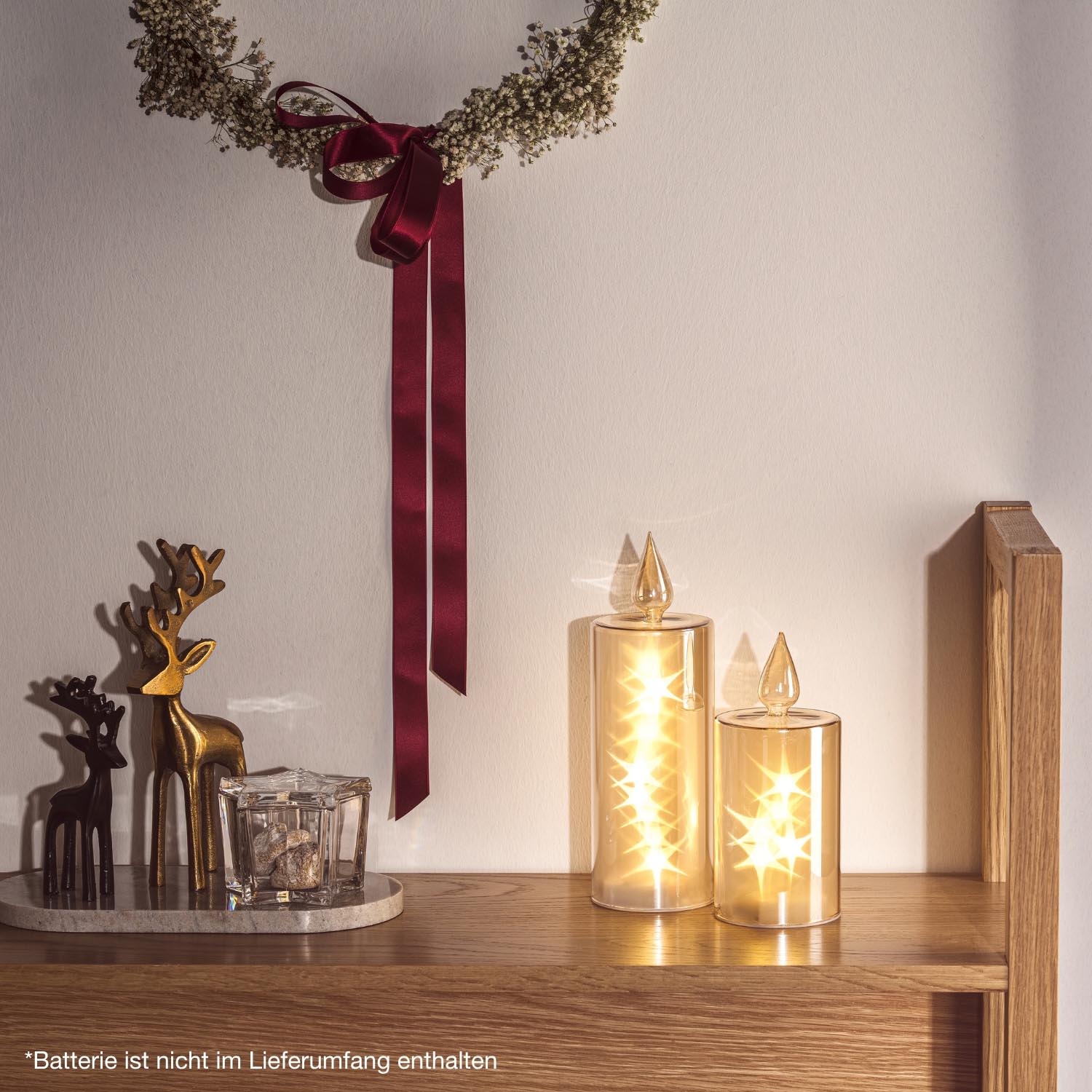 LED Kerze RIPOSO auf Holzregal mit weihnachtlicher Dekoration und Hirschfiguren