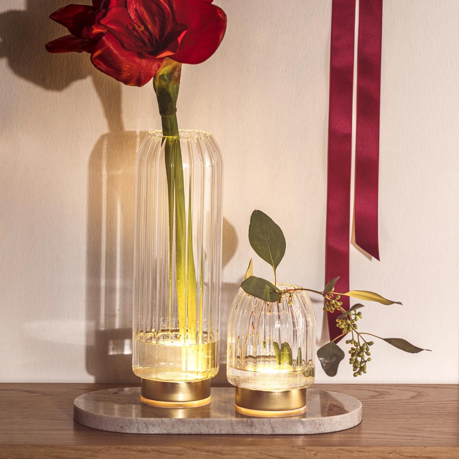LED Vase RIPOSO mit roter Blume auf Holzablage neben Deko-Elementen