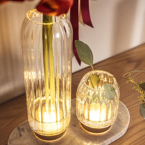 LED Vase RIPOSO mit warm leuchtenden Glasgravuren und Eukalyptuszweigen, auf Holztisch arrangiert