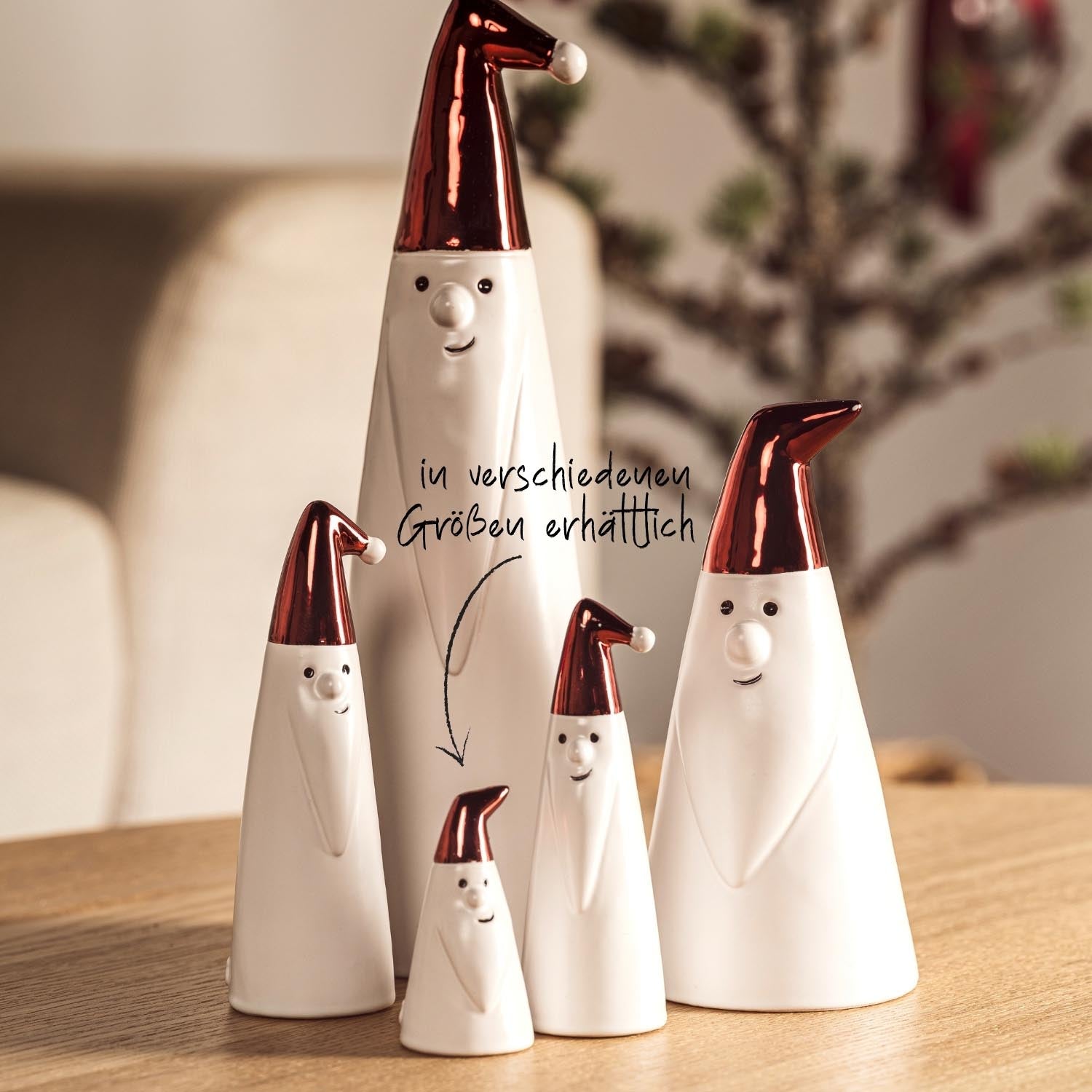 Weihnachtsmänner GIANNI in verschiedenen Größen mit roten Mützen auf Holztisch