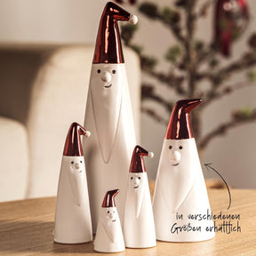 Weihnachtsmänner in verschiedenen Größen mit roten Mützen auf Holztisch, Wohnraum