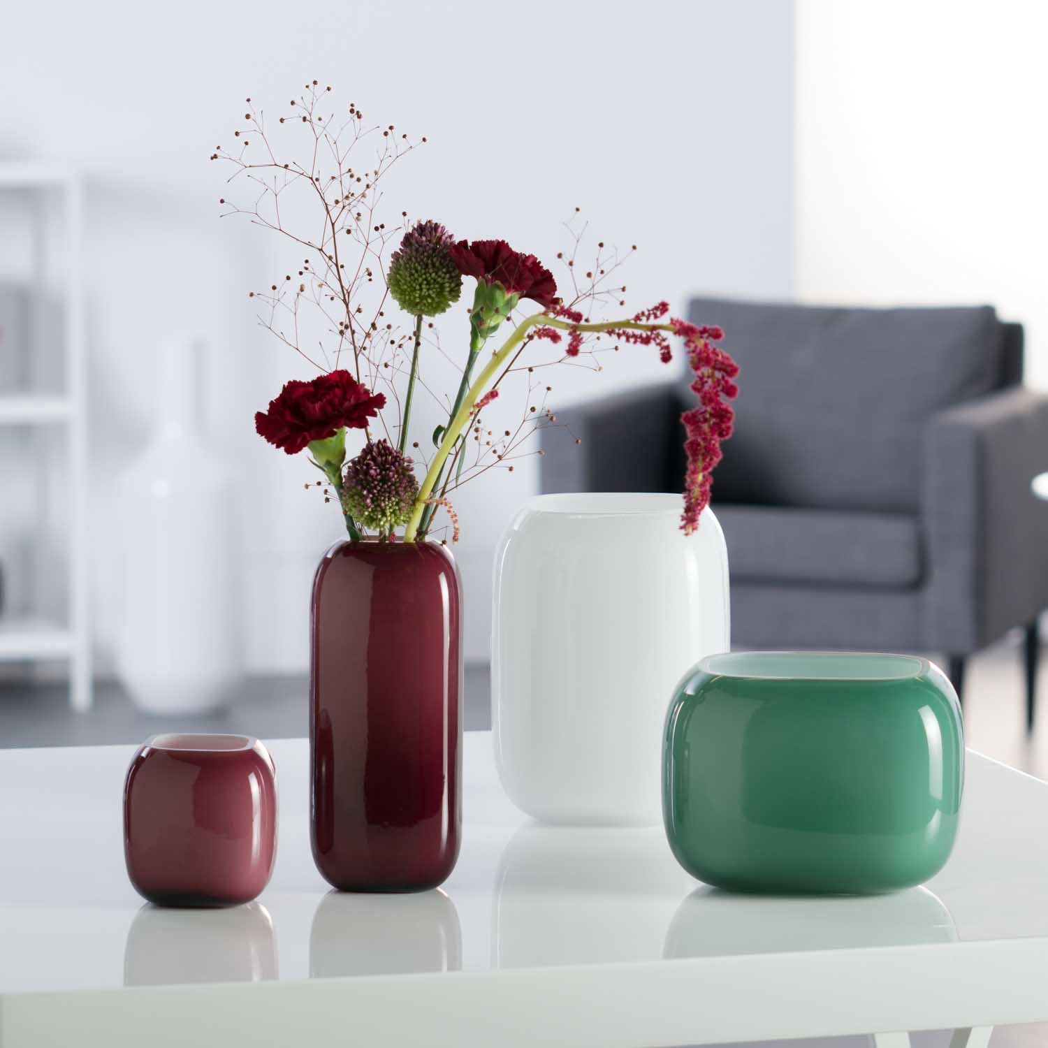Vase MILANO weiß mit Blumenarrangement in Wohnzimmer neben anderen Vasen