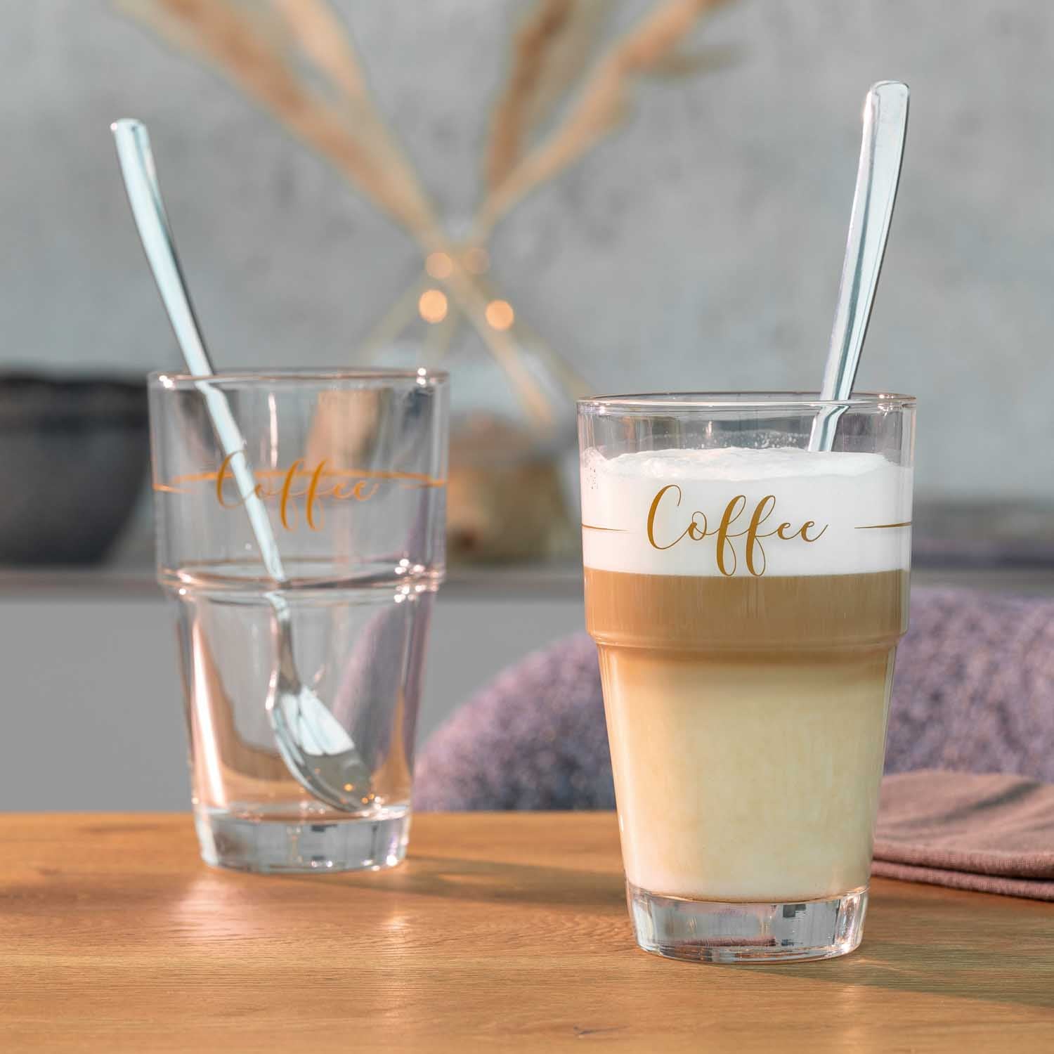 Becher SOLO mit Kaffeegetränk, Glas Wasser und Strohhalmen auf Holztisch
