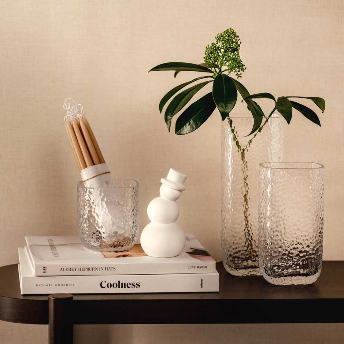 Tischlicht MARTELLO auf schwarzem Tisch mit Büchern, Kerzen und Pflanze in Vase