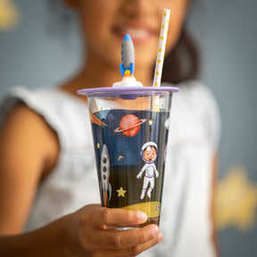 Kind hält Trinkglas BAMBINI AVVENTURA mit Weltall-Motiv und Strohhalm