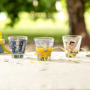 Drei Gläser mit Weltall-Motiven gefüllt mit gelber Limonade auf Gartentisch