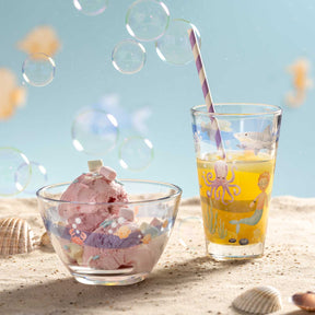 Schale BAMBINI AVVENTURA mit buntem Meerdesign auf Sand, neben Getränk und Seifenblasen