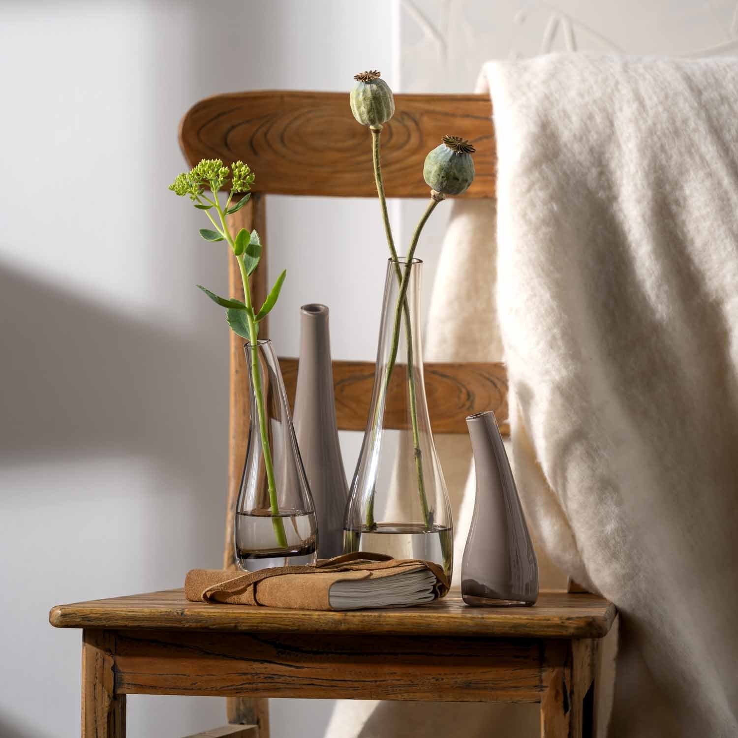 Vase ARCO mit Blumen auf Holztisch in Wohnraum
