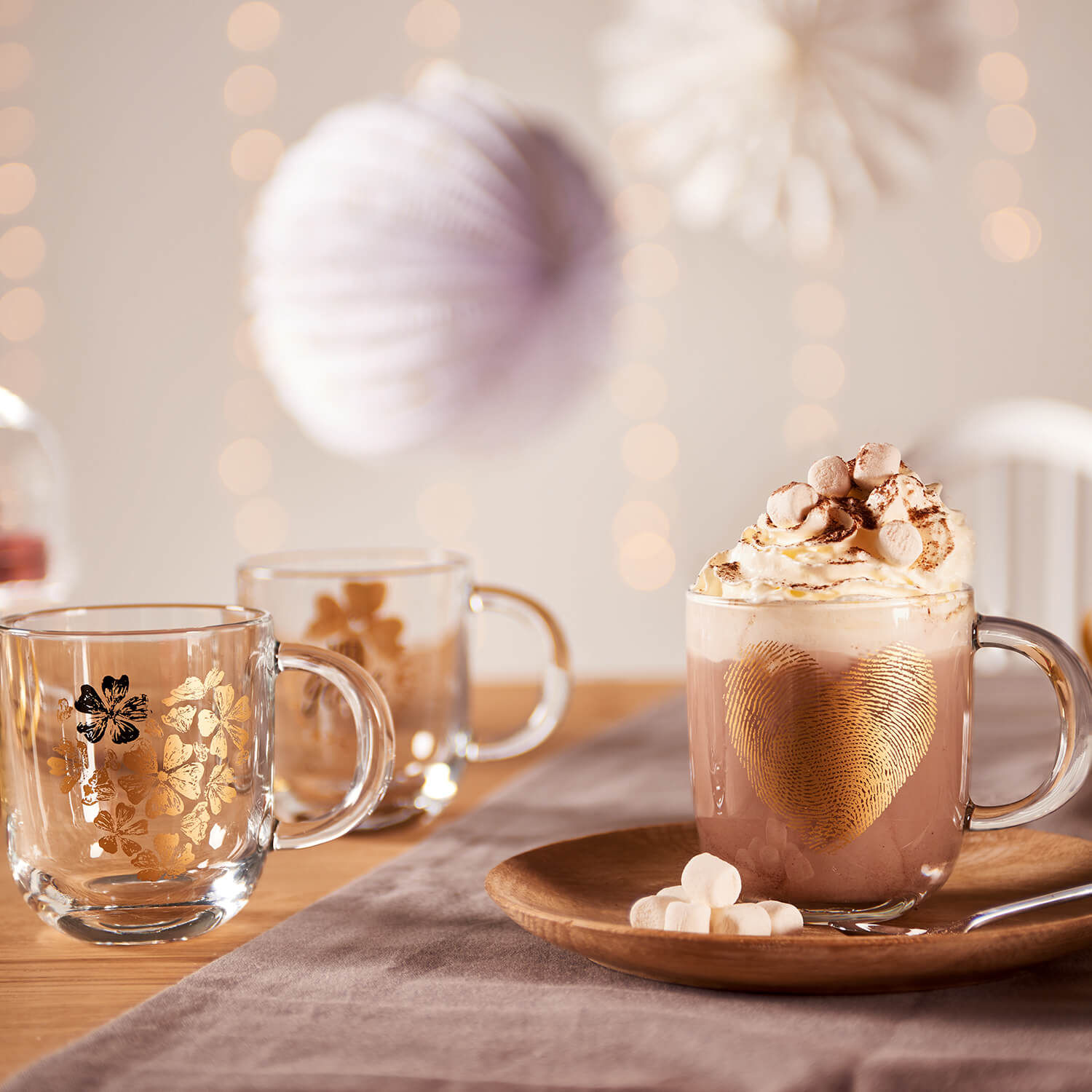 Tasse EMOZIONE mit Blumenherz-Motiv auf gedecktem Tisch mit Dekoration