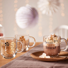 Tasse EMOZIONE mit Gravur auf dekoriertem Tisch, Weihnachtsatmosphäre