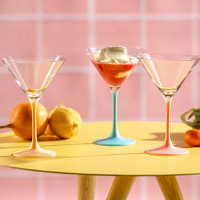 Cocktailschale BRERA 230 ml 6er-Set in mehrfarbigen Varianten mit Cocktails und Zitrusfrüchten auf gelbem Tisch