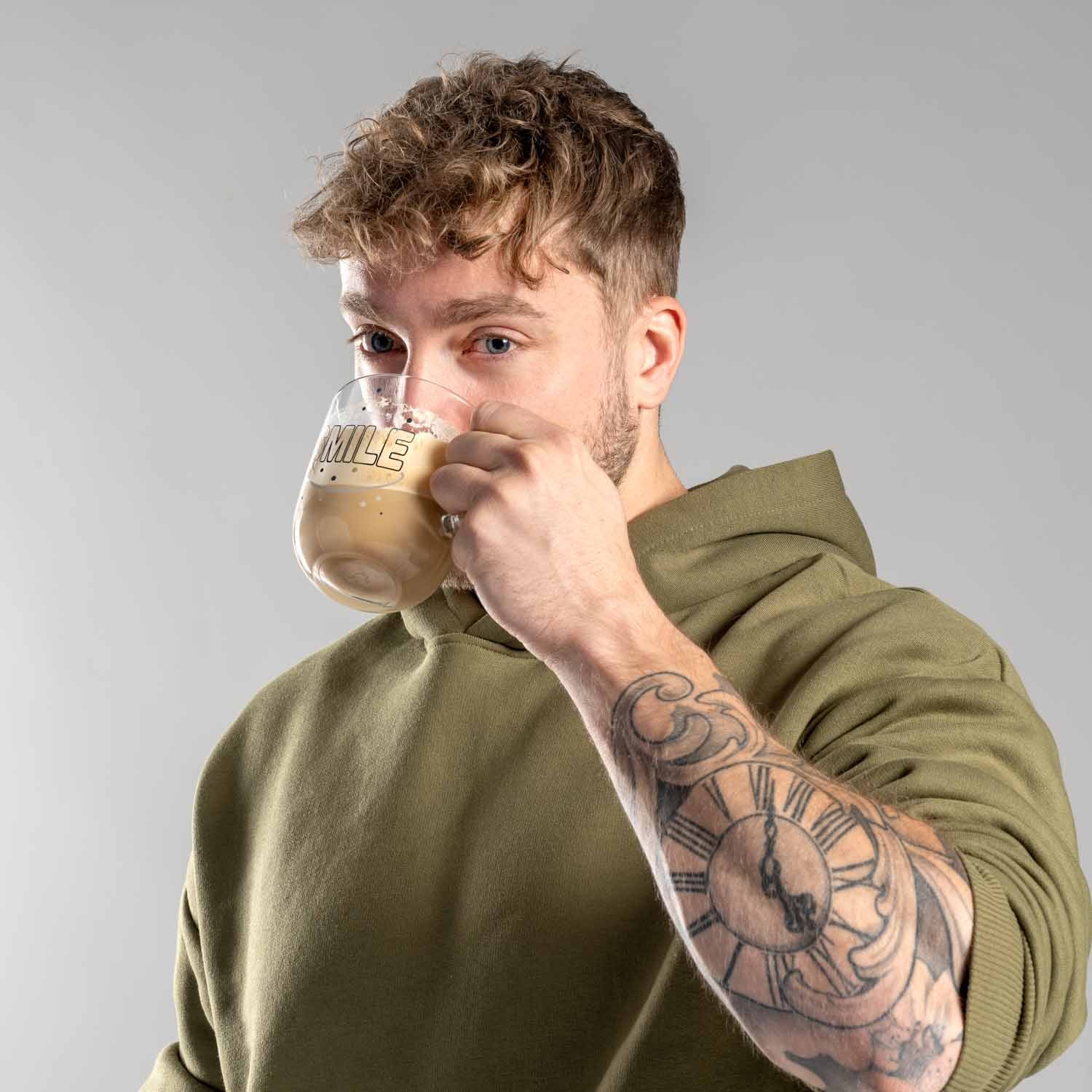 Mann trinkt aus Tasse UFFICIO 400 ml SMILE, olivgrüner Pullover