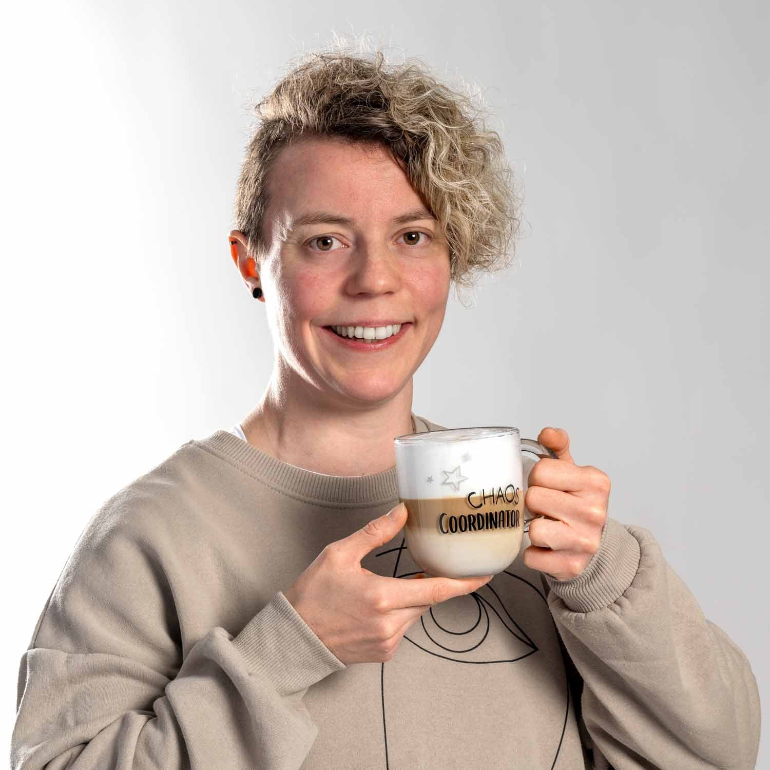 Frau hält Glastasse UFFICIO 400 ml 'CHAOS COORDINATOR' mit beidseitiger Gravur
