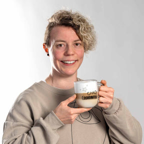 Frau hält Glastasse UFFICIO 400 ml 'CHAOS COORDINATOR' mit beidseitiger Gravur