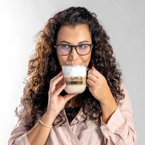 Frau mit Brille hält Glastasse CHAOS COORDINATOR zum Trinken vor Gesicht