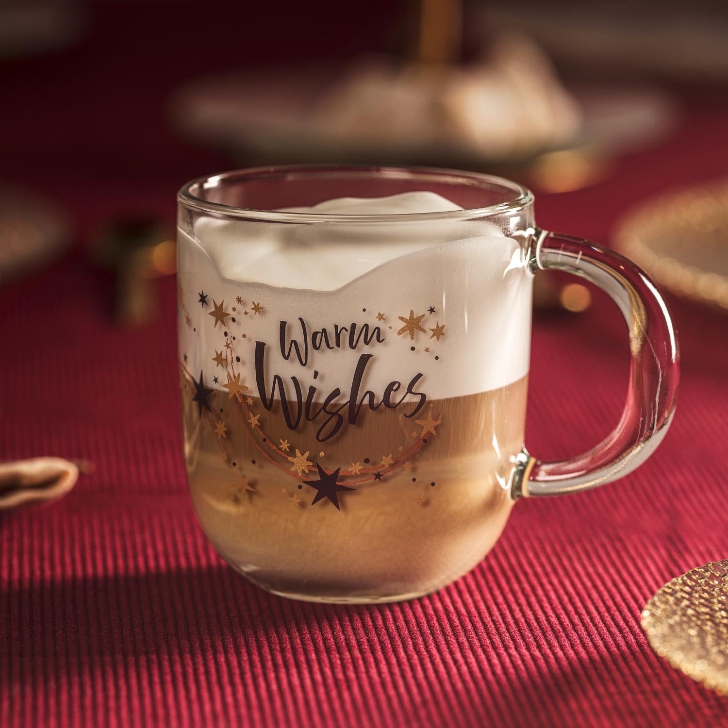 Tasse RIPOSO mit Warm Wishes Gravur, gefüllt mit Kaffee auf rotem Tisch