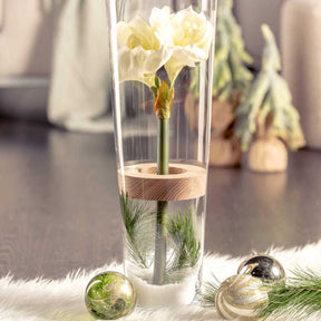Vase MAGICO mit gelber Iris, Holzeinsatz und Dekoelementen auf grauem Untergrund