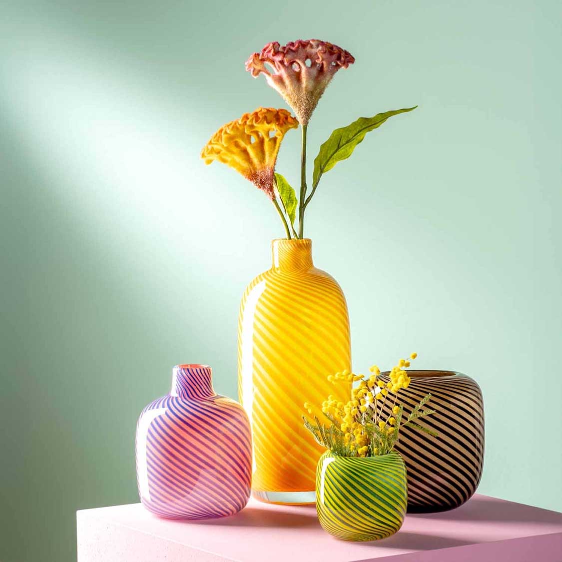 Vase FILO COLORI pink mit Blumen und anderen farbigen Vasen arrangiert