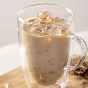 Doppelwandtasse DUO mit Eiskaffee und Eiswürfeln gefüllt, auf Holzuntergrund