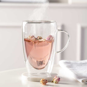 Doppelwandtasse DUO mit Rosenblütentee und Rosenblüten auf weißem Untergrund
