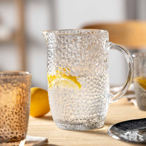 Krug MATERA mit Zitronenscheibe auf Holztisch, Glas daneben