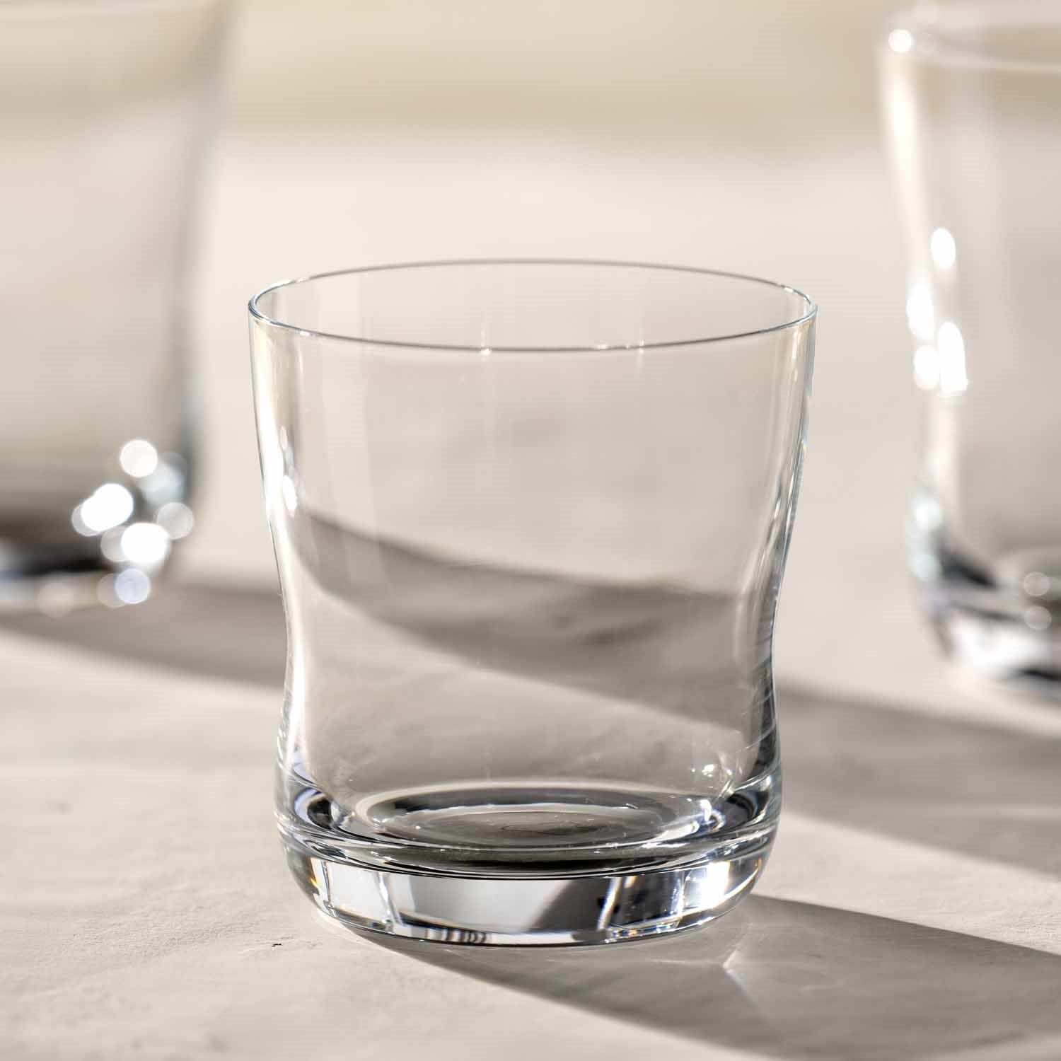 Trinkglas VITA 330ml auf hellem Untergrund mit weiteren Gläsern im Hintergrund