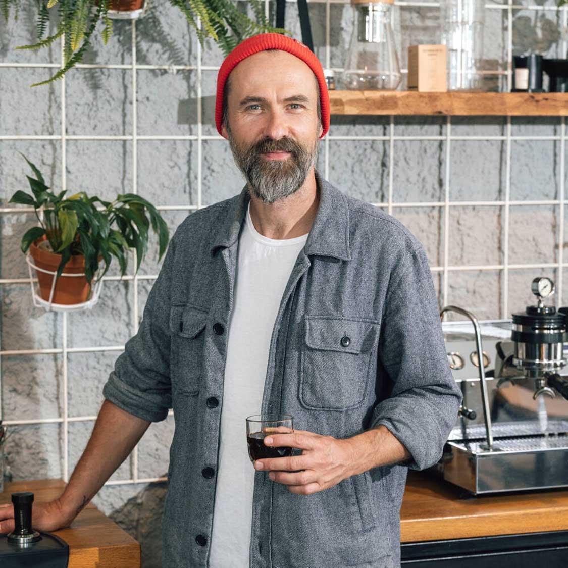Mann mit Espressoglas in Werkstatt-Umgebung