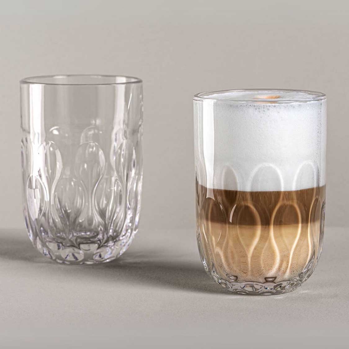 Zwei Latte Macchiato Gläser GOCCE nebeneinander, eines leer, eines mit brauner Flüssigkeit gefüllt