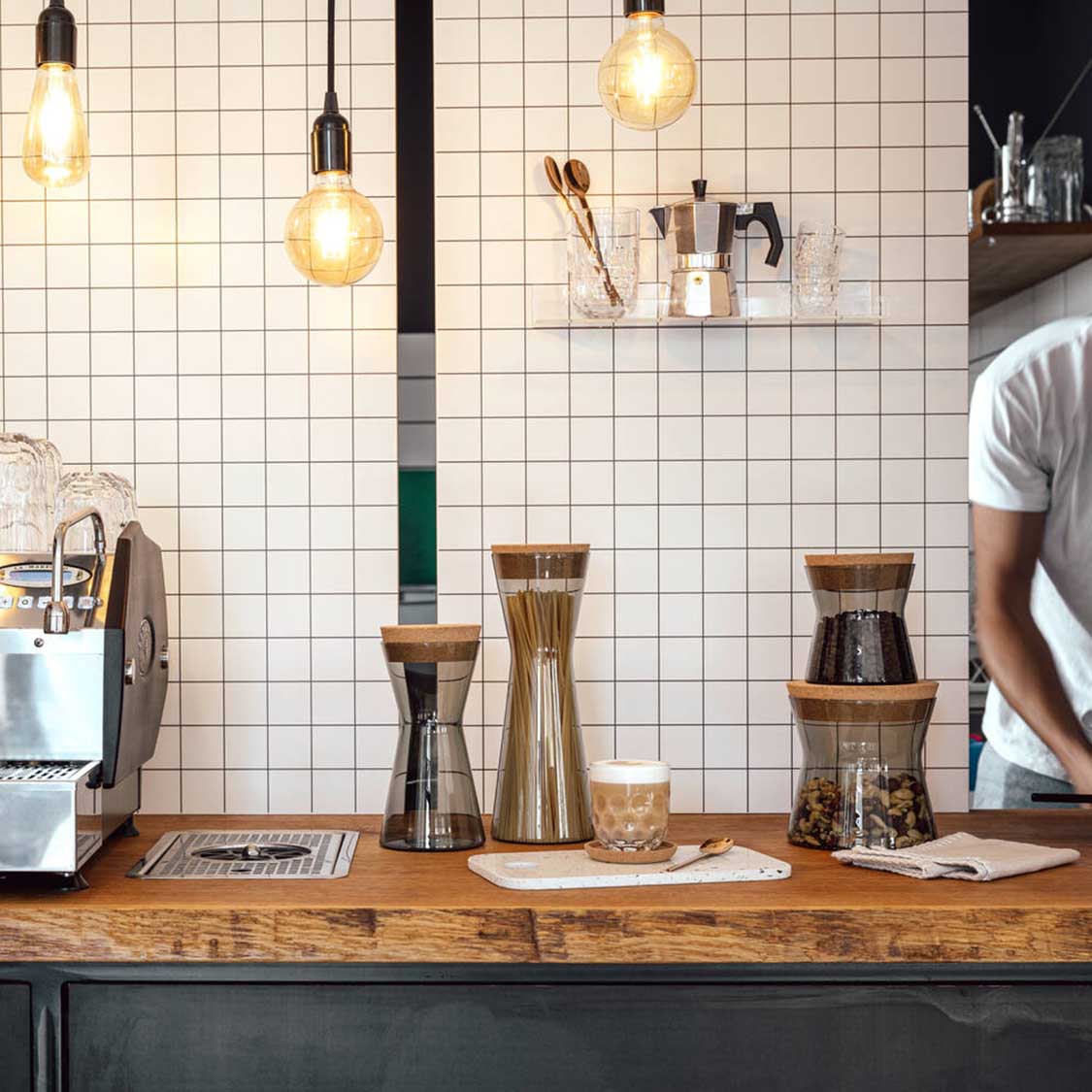 Dose FORMA X auf Theke in moderner Kaffee-Bar neben Espresso-Maschine