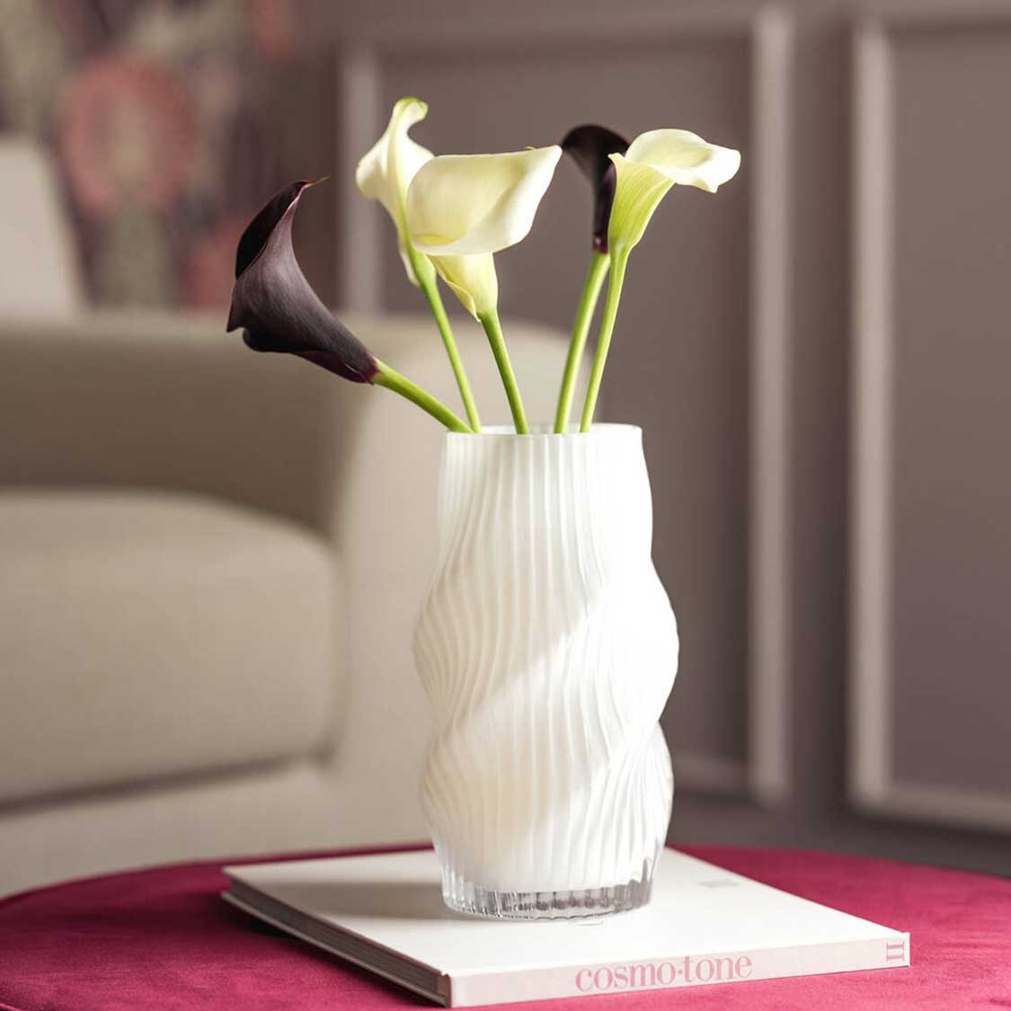 Vase VERDI mit gelben und dunklen Calla-Lilien auf Beistelltisch im Wohnraum