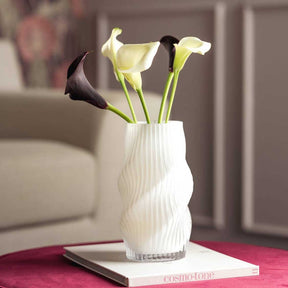 Vase VERDI mit gelben und dunklen Calla-Lilien auf Beistelltisch im Wohnraum