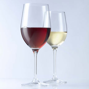 Zwei Weißweingläser mit Rotwein und Weißwein gefüllt, auf weißem Hintergrund