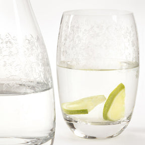 Trinkglas CHATEAU gefüllt mit Wasser und Limettenscheiben, daneben eine Karaffe