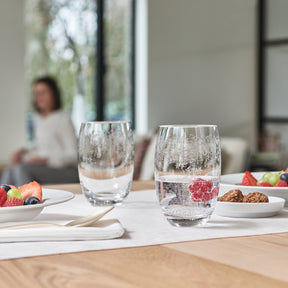 Trinkglas CHATEAU mit Wasser und Himbeeren auf gedecktem Tisch