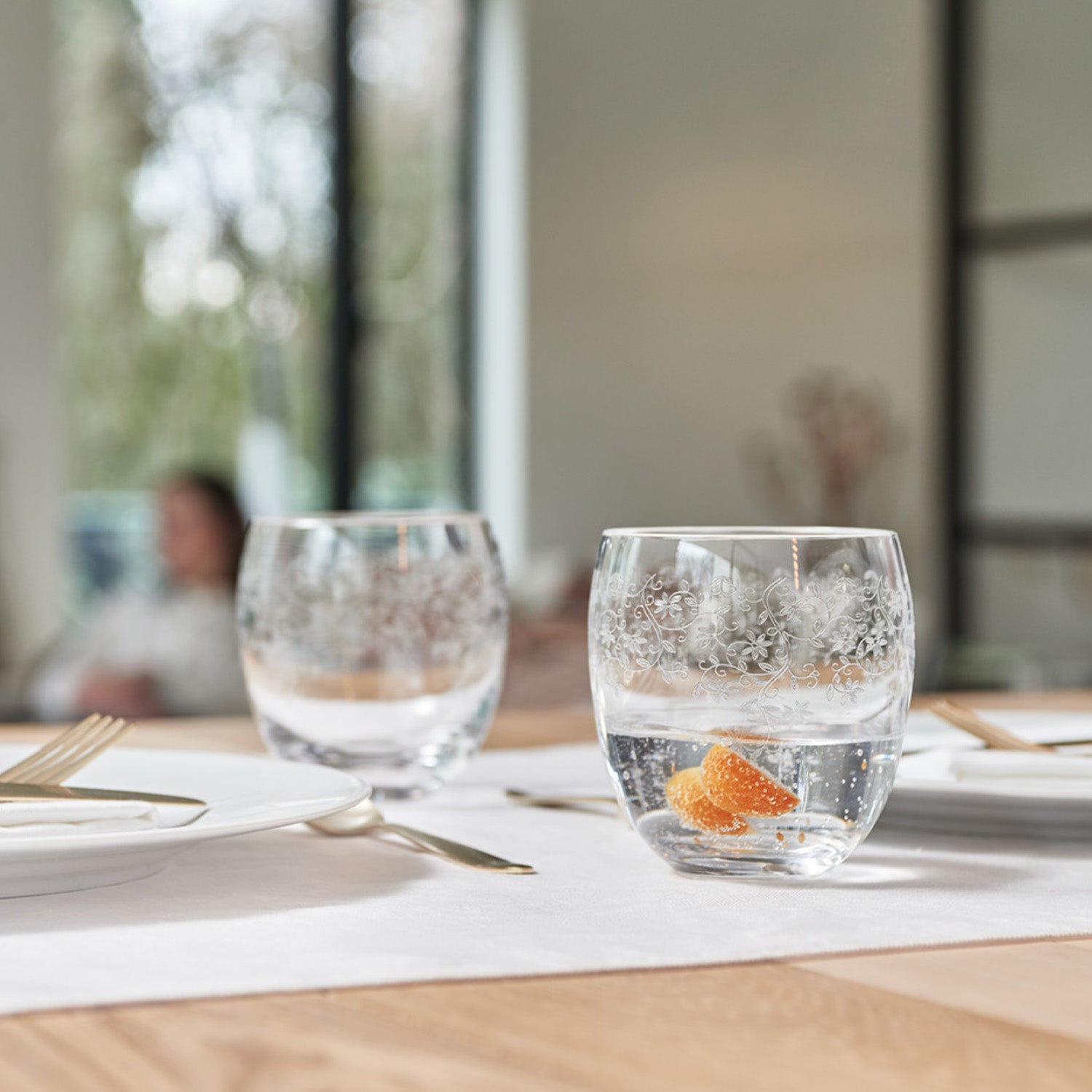 Trinkglas CHATEAU 400 ml mit Wasser und Zitronenscheibe auf gedecktem Tisch