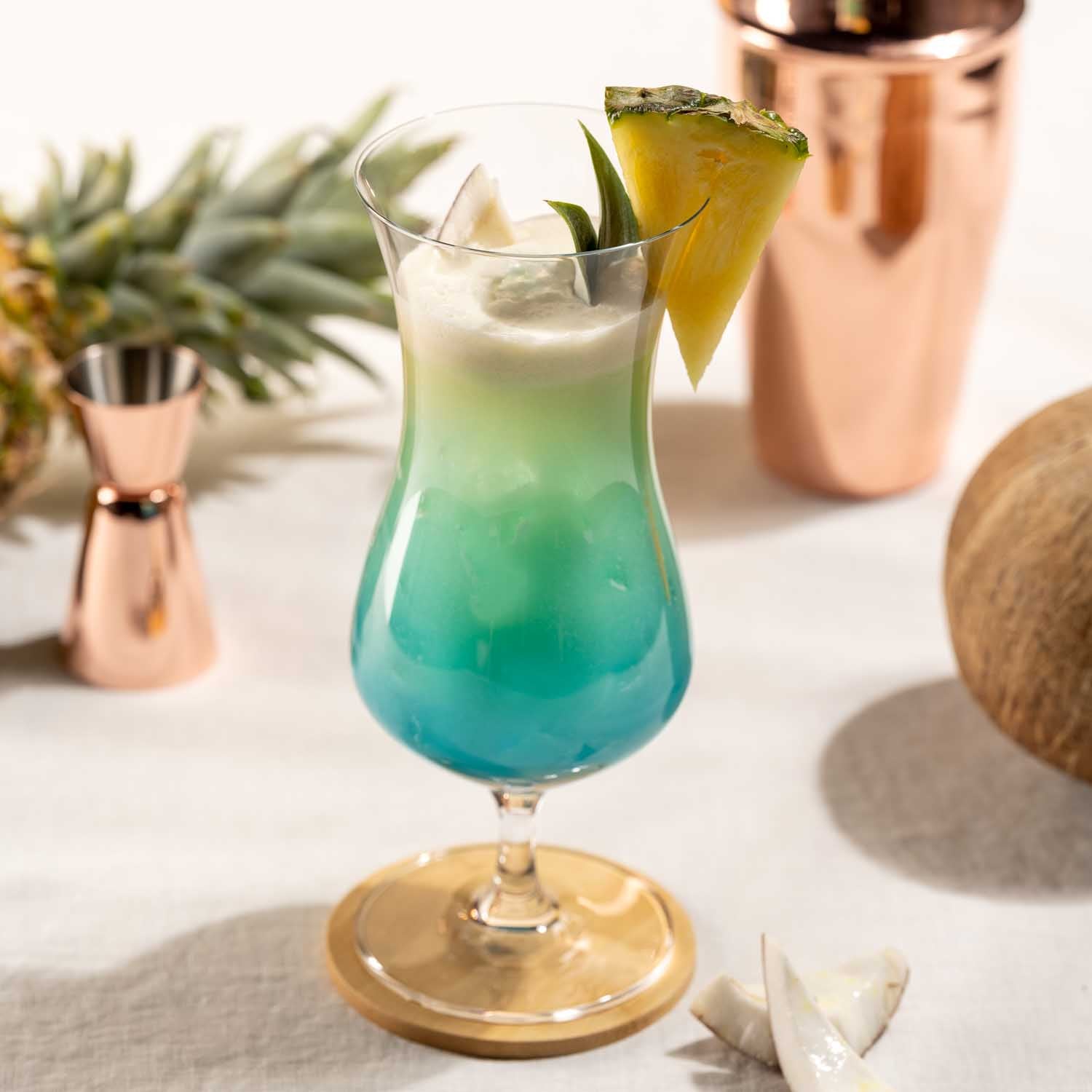 Hurricane Glas IL MONDO mit Cocktail, Ananasscheibe und Barwerkzeugen auf Tisch