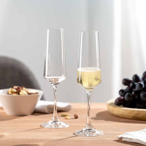 Sektglas PALADINO auf gedecktem Tisch mit Trauben und Nussschale