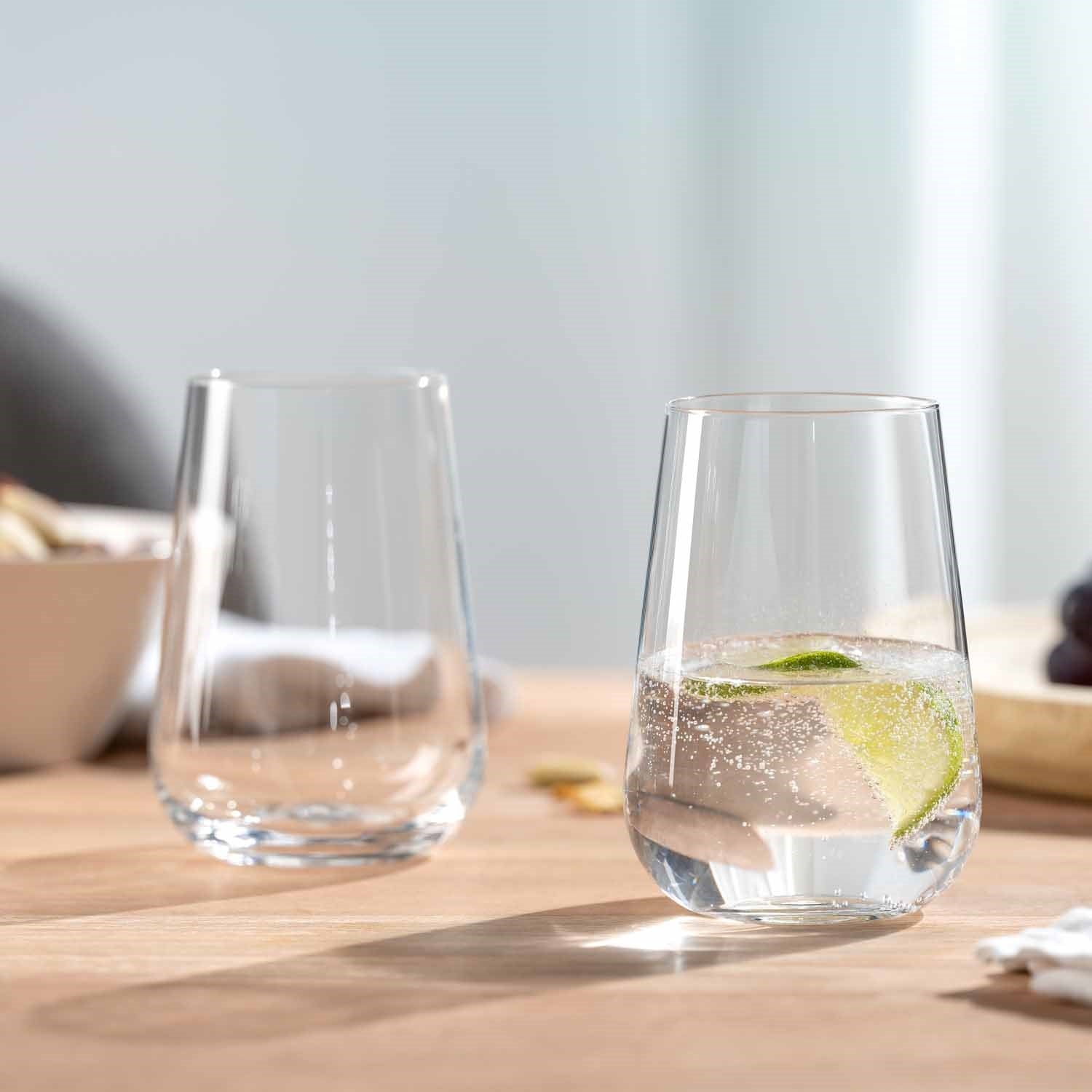 Zwei Trinkgläser PALADINO auf Holztisch, eines gefüllt mit Wasser und Limette
