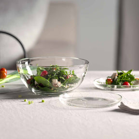 Glasschalen mit Salat auf gedecktem Tisch, Teller daneben