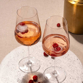 Zwei Rotweingläser BRUNELLI mit Roséwein und roten Beeren auf weißem Untergrund