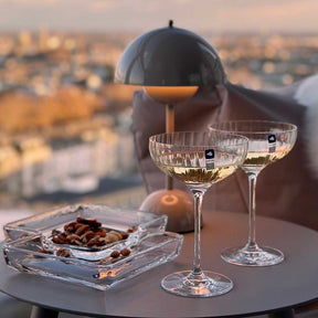 Champagnerschalen POESIA mit Weißwein auf Dachterrasse mit Stadtblick und Nüssen